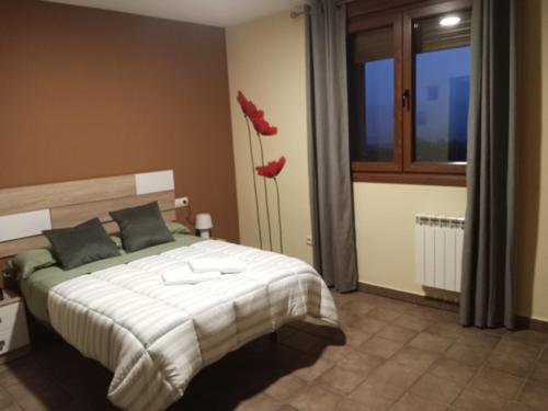 Un dormitorio con una cama con zapatos rojos. en Hotel Rural Mirador de Solana, en Solana de Ávila