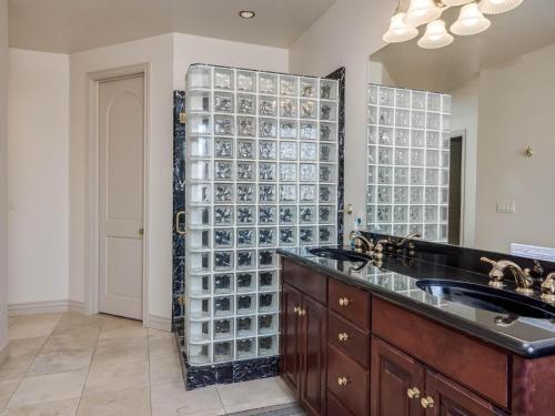 a bathroom with a sink and a large glass wall at Riviera Retreat in Salt Lake with Private Hot Tub and Theater in Millcreek