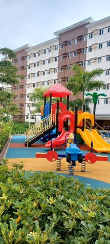 a playground in front of a large building at Mudjhako’s Staycation in Trece Martires