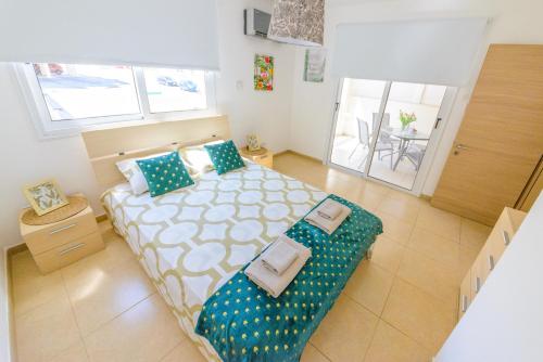 a bedroom with a bed with blue and white pillows at 1 bed, Kapparis, Thea - 1B in Paralimni