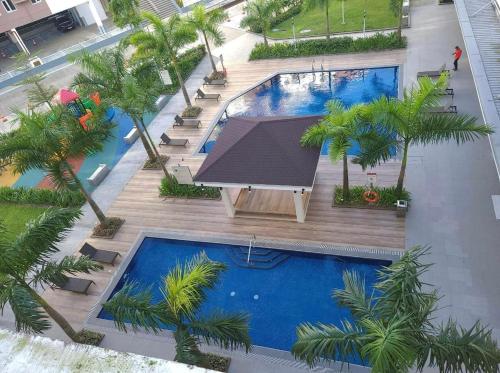 an overhead view of a swimming pool with palm trees at Mudjhako’s Staycation in Trece Martires