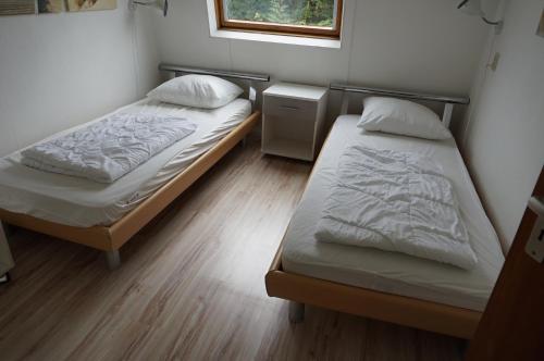 1 Schlafzimmer mit 2 Betten und einem Fenster in der Unterkunft Kustverhuur Park Schoneveld Zeester 66 in Breskens