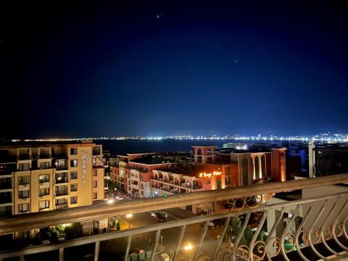 a view of a city at night from a balcony at Grand Sea View Penthouse in Sveti Vlas