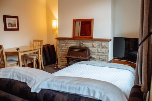 a bedroom with a fireplace and a bed and a table at Rustic Cottage in Heart of Town in Otley