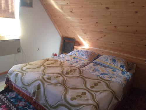 a bed in a room with a wooden wall at Goran in Jahorina