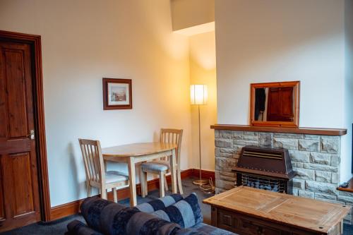 a living room with a table and a fireplace at Rustic Cottage in Heart of Town in Otley