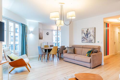a living room with a couch and a table at Luxueux Appartement Design 70m2 Disneyland Paris pour 6pax in Chessy