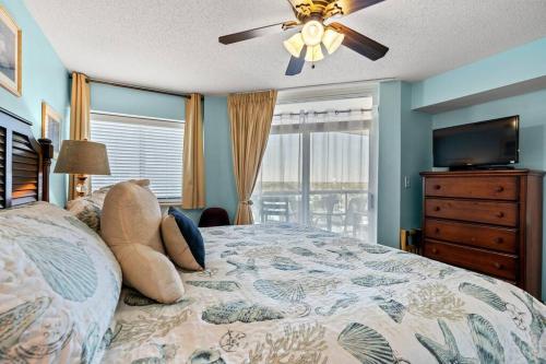a bedroom with a bed and a ceiling fan at Oceanfront Get Away in Myrtle Beach