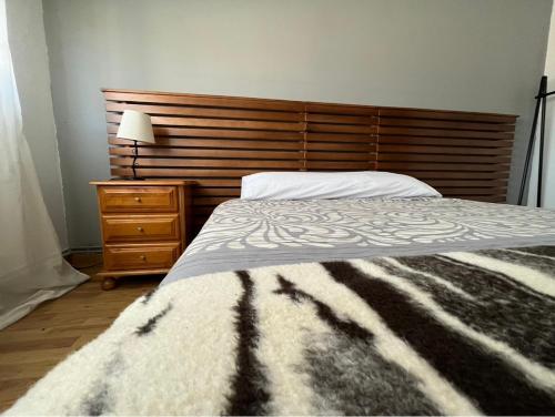 a bedroom with a bed and a wooden headboard at Pension Matias Rooms in Sarria