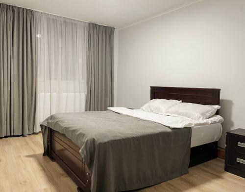 a bedroom with a bed with white sheets and a window at View Corner in Tbilisi City