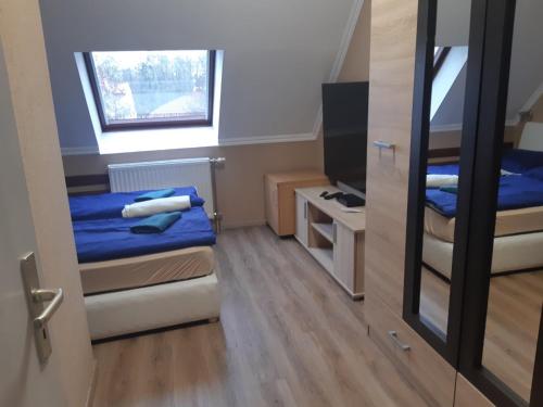 ein kleines Zimmer mit 2 Betten und einem Spiegel in der Unterkunft Bajnok Apartman in Hévíz