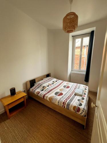 a small bedroom with a bed and a window at Appartement T2 avec terrasse proche cathédrale in Bourges