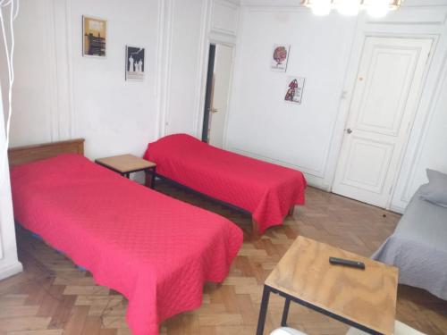 two beds in a room with red covers at Hostal Salvador in Santiago