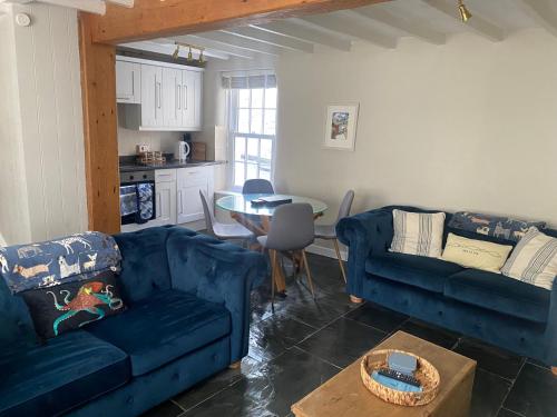 a living room with two blue couches and a table at The Retreat in Aberdyfi
