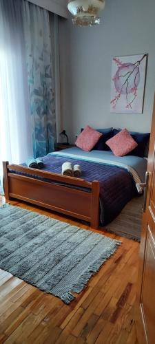 1 dormitorio con 1 cama grande con almohadas rosas en Like your home en Komotini