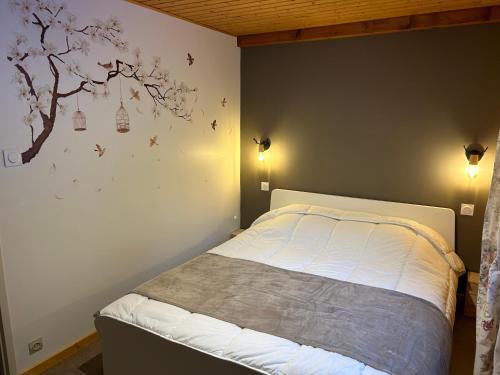 - une chambre avec un lit et un arbre sur le mur dans l'établissement Joli Duplex sur la rive du lac, à Gérardmer