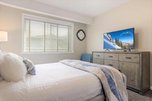 a bedroom with a bed and a flat screen tv at Union Cove 3-Plex in Salt Lake with Hot Tub in Midvale