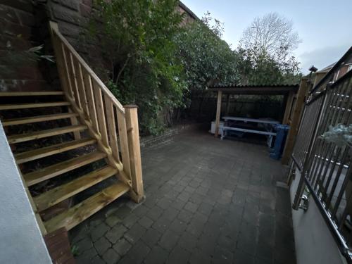 a patio with a wooden stairway next to a building at New city flat, 3 x double bed en-suite bedrooms, private kitchen & lounge, free private parking & own workspaces in Exeter
