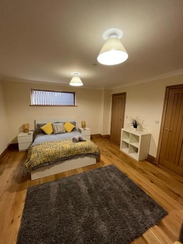 a bedroom with a bed and a rug at New city flat, 3 x double bed en-suite bedrooms, private kitchen & lounge, free private parking & own workspaces in Exeter