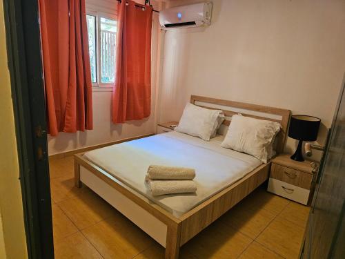 VILLA VALIHA في Koungou: غرفة نوم صغيرة عليها سرير وفوط
