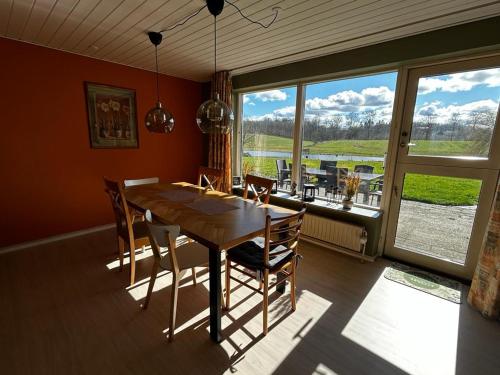 uma sala de jantar com uma mesa de madeira e cadeiras em Annex88 B&B em Fårvang