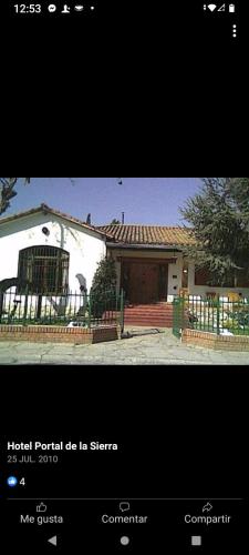 a picture of a white house with a fence at Portal de las sierras hotel in La Falda