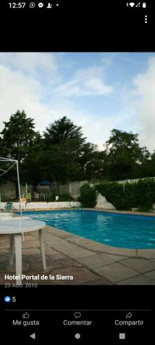 a picture of a pool with a table next to it at Portal de las sierras hotel in La Falda