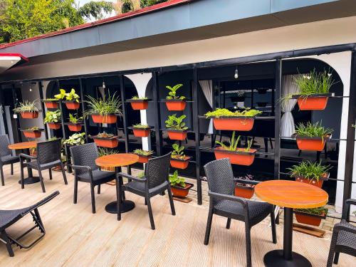 a patio with tables and chairs and potted plants at ADDRESS HOTELS AND TOWERS MAITAMA in Abuja