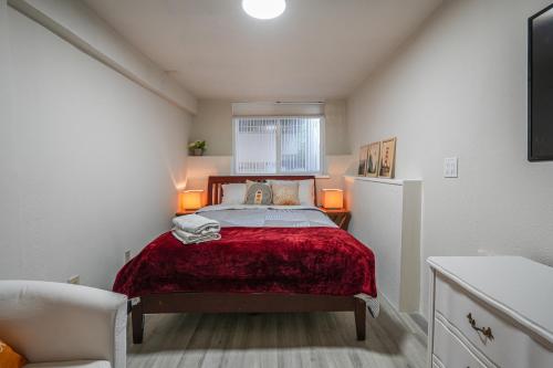 a small bedroom with a bed with a red blanket at San Francisco Apartment about 5 Mi to Downtown! in San Francisco