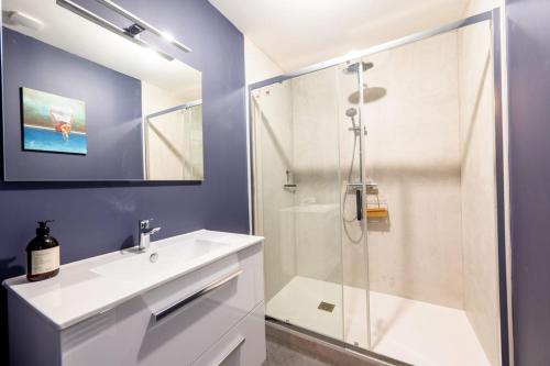 La salle de bains est pourvue d'un lavabo blanc et d'une douche. dans l'établissement Le Central - Au coeur de Bourges, à Bourges