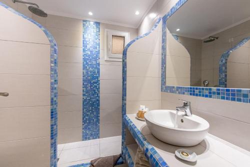 a bathroom with a sink and a mirror at Reverie Santorini Hotel in Firostefani