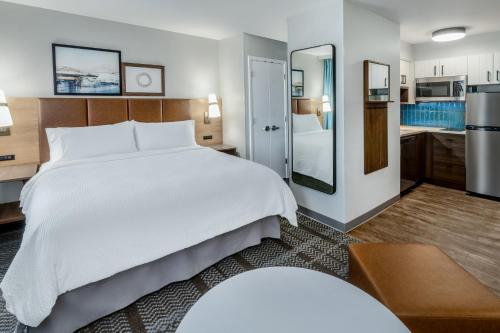 1 dormitorio con 1 cama blanca grande y cocina en Staybridge Suites Denver - Cherry Creek, an IHG Hotel en Denver