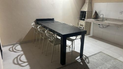 - une table et des chaises noires dans la cuisine dans l'établissement Ap Praia de Taperapuan Porto Seg, à Porto Seguro
