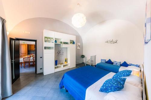 a bedroom with a blue and white bed and a dining room at Maika House - Amalfi Coast - Seaview in Atrani