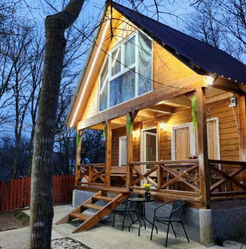 a tiny house on a porch with a table and chairs at Wooden House Kopiti in Tbilisi City