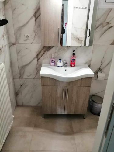 a bathroom with a sink and a mirror at Villa Paradisos in Likóstomon