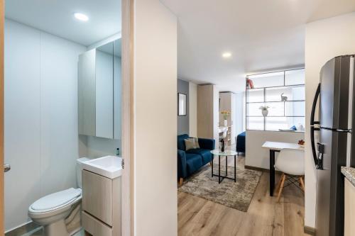 a bathroom with a sink and a toilet and a kitchen at Torre Ventto Lofts in Bogotá