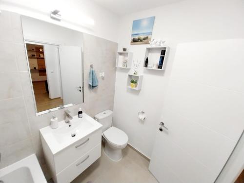 uma casa de banho branca com um WC e um lavatório em Panoramic City View Apartment em Târgu-Mureş