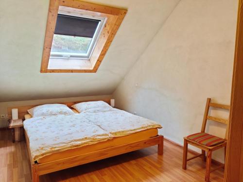 um quarto com uma cama, uma janela e uma cadeira em Ferienhaus Route 5 em Elmstein