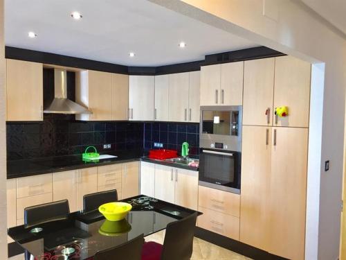 a kitchen with white cabinets and a black counter top at TERRAMAR in Villajoyosa