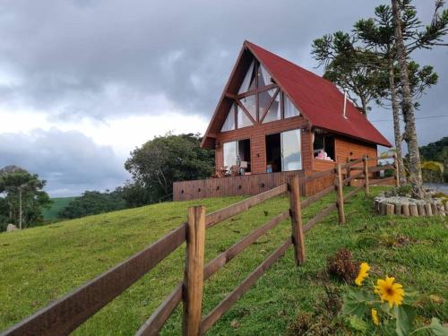 een huis op een heuvel met een hek bij Cabana na montanha, com hidro e vista espetacular. 