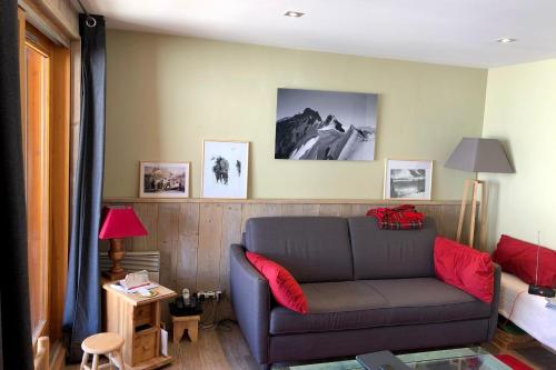 een woonkamer met een bank en foto's aan de muur bij Cosy and spacious family nest with superb view in Courchevel
