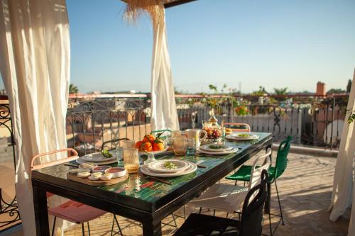einen Tisch auf einem Balkon mit Essen drauf in der Unterkunft Cosy Riad in Marrakesch