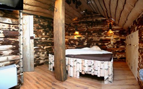 1 dormitorio en una cabaña de madera con 1 cama. en B&B Le Perchoir en Libin