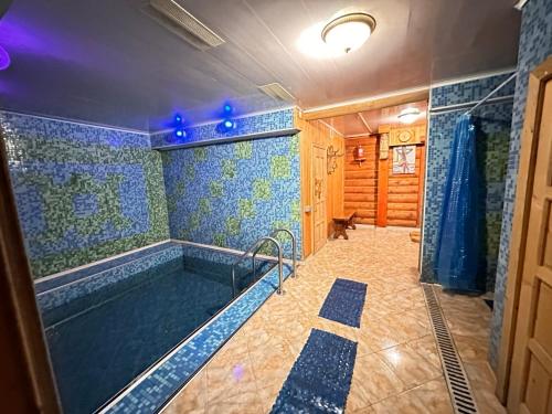 a bathroom with a large tub with blue tiles at Trembita in Mizhhirʼʼya