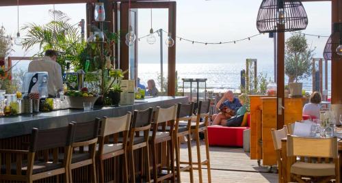 un restaurante con bar y gente sentada en las mesas en Wellness Lodge Ruigenhoek 13A - Sauna, Jacuzzi ! en De Zilk