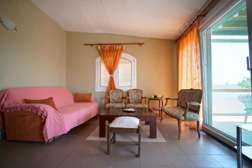 ÁvdhiraにあるSeaside Houseのベッドルーム(ピンクベッド1台、テーブル、椅子付)