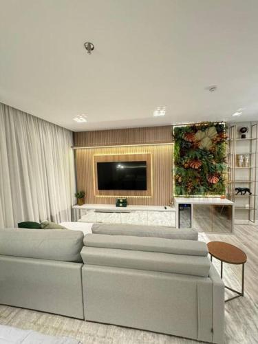 Una sala de estar con un sofá y un televisor de pantalla plana. en Infinity Tower Flat - 1403, en Itapema