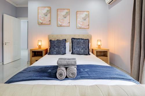 a bedroom with a large bed with towels on it at Gemmell Place by HostAgents in Durban
