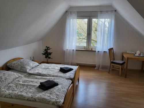 - une chambre avec 2 lits et une fenêtre dans l'établissement Ferienwohnung Gästehaus Bauer, à Heiligenhaus